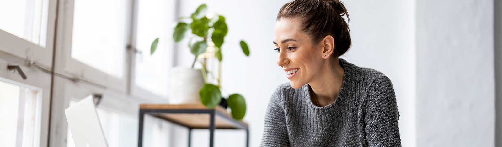 Młoda kobieta pracująca na laptopie w kawiarni