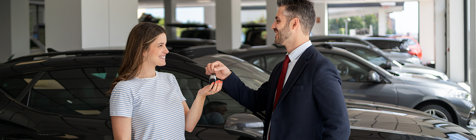 Sprzedawca przekazuje kobiecie kluczyki do samochodu