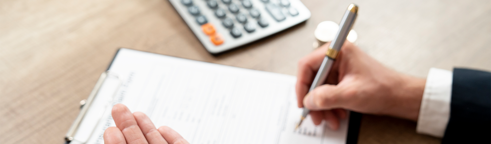 Dłoń z kluczykami, formularz i kalkulator