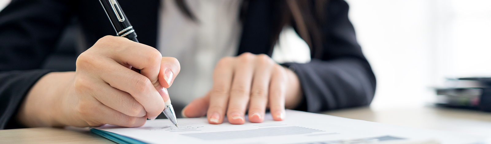 Kobieta podpisująca dokumenty