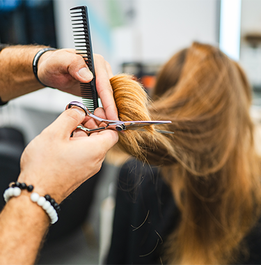 Młoda kobieta podczas strzyżenia włosów