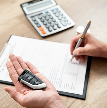 Dłoń z kluczykami, formularz i kalkulator