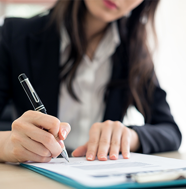Kobieta podpisująca dokumenty